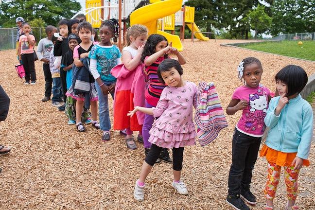 Kids lining up on a playground to go in to class